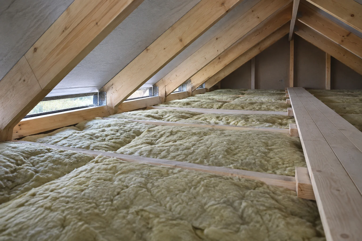 Nærbilde av isolasjon mellom bjelker på et kaldt loft